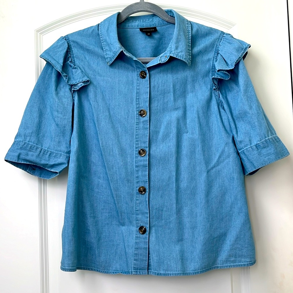 Medium chambray blouse with ruffle sleeve detail.